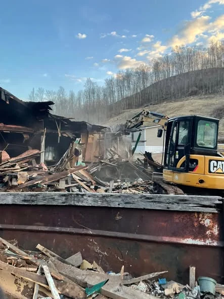 Excavator working through demolition debris