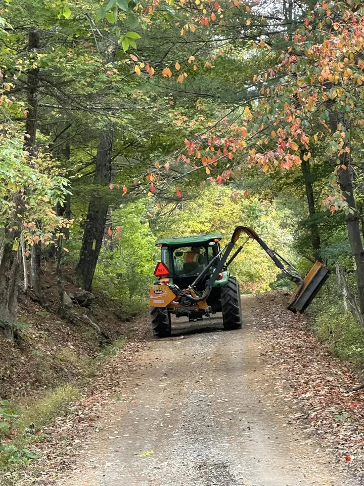 B&K Excavating roadside mowing equipment working on a wooded road